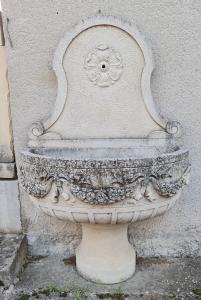 Fontana in pietra bianca con frontone